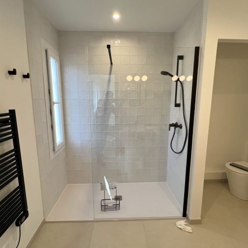 Une douche à l’italienne minimaliste aux finitions contrastées noir & blanc.