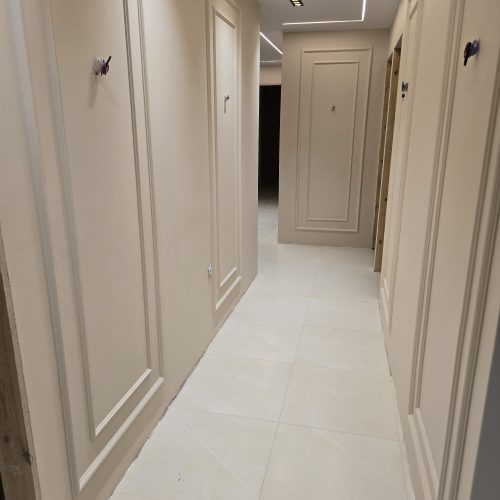 Couloir rénové à Lyon avec moulures murales classiques et éclairage LED moderne au plafond