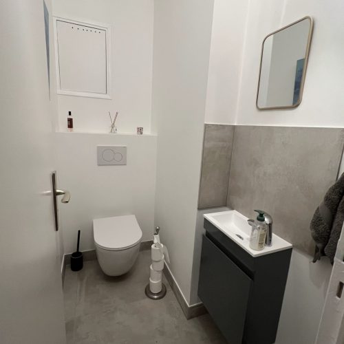 WC suspendus et lave-mains noir dans un style épuré et fonctionnel.